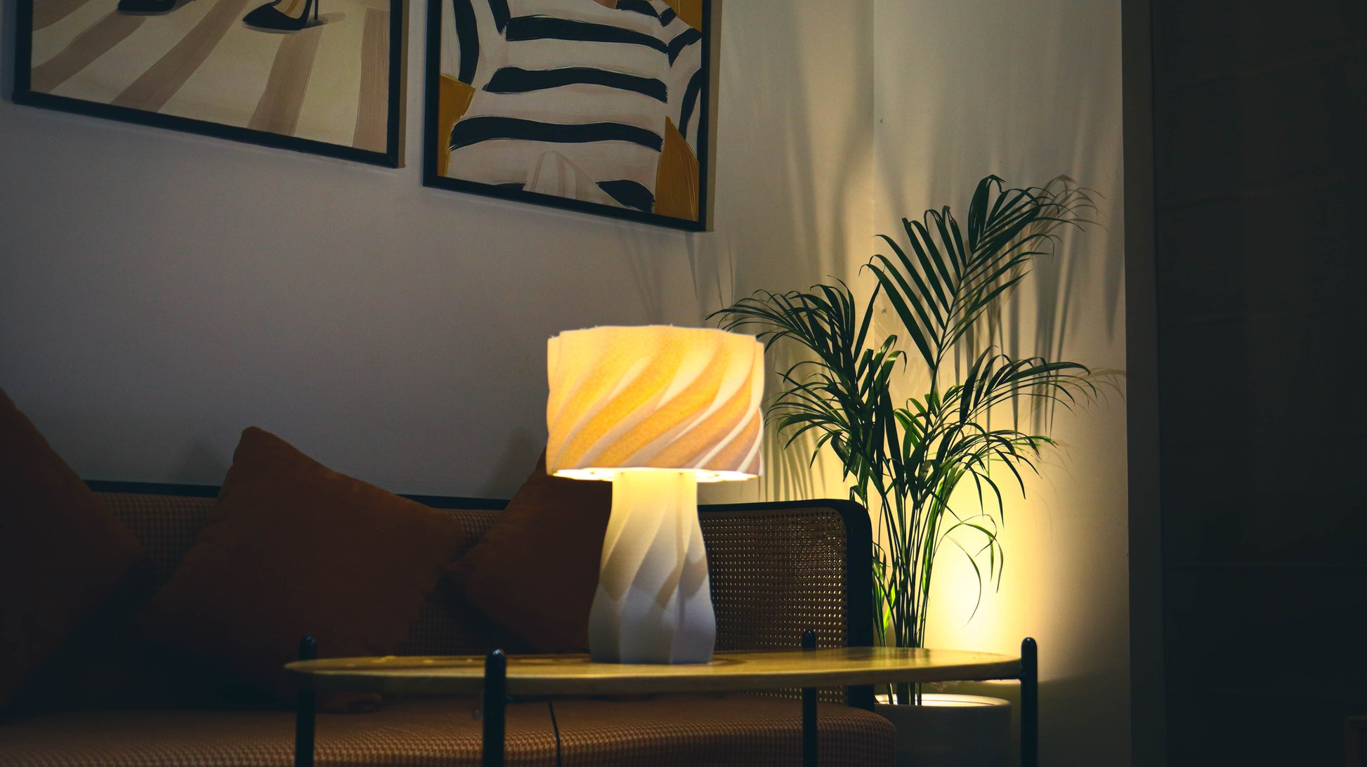 Aurelia table lamp lit at night with amber glow through ribbed shade