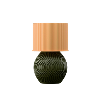 Table lamp with a textured green base and a peach lampshade on a white background