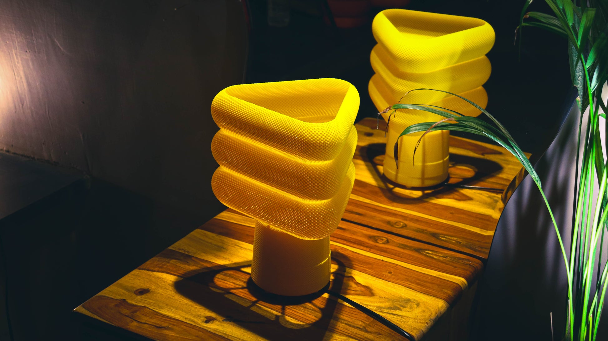 Textured yellow lamps with spiral triangular top, illuminated cozy setting