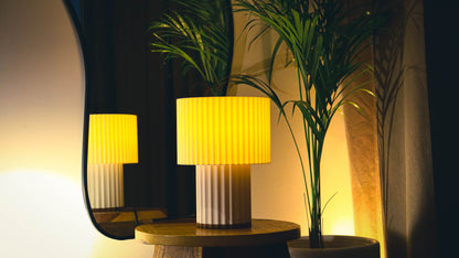 Ribbed drum table lamp with double-tier pleated design, warm ambient glow