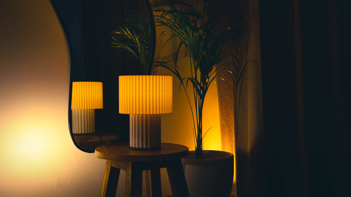 Contemporary pillar lamp, ribbed pleated shades stacked, warm interior lighting