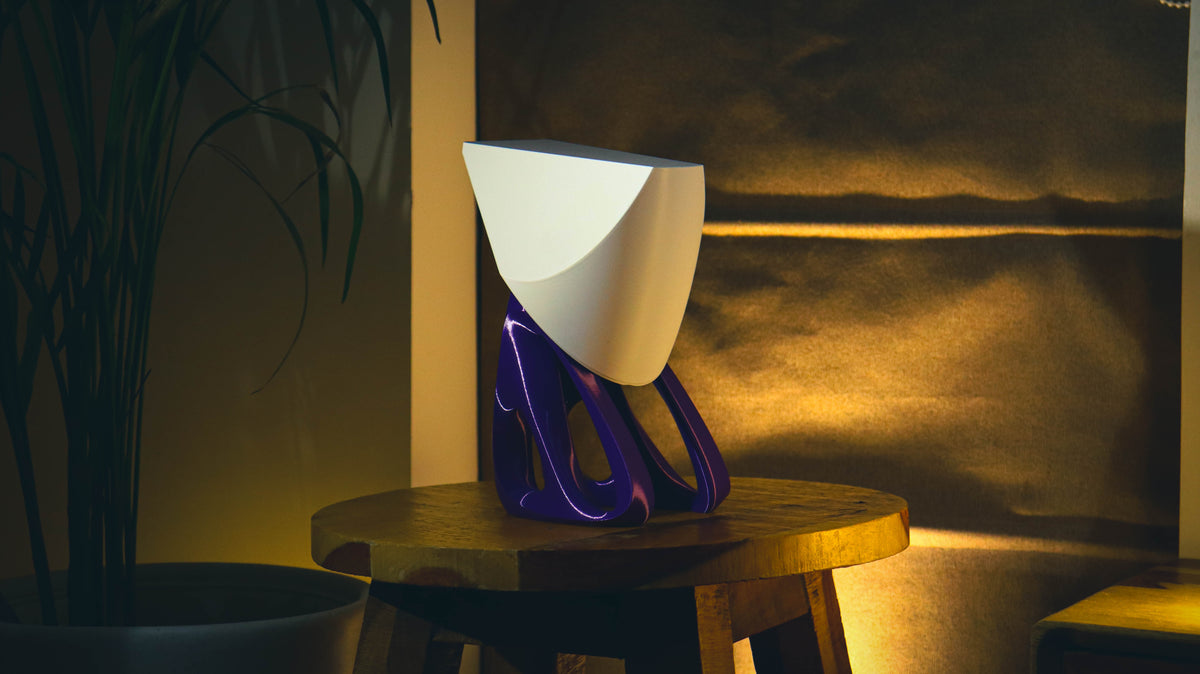Zenith Lamp with white angular shade and purple sculptural base on wooden stool