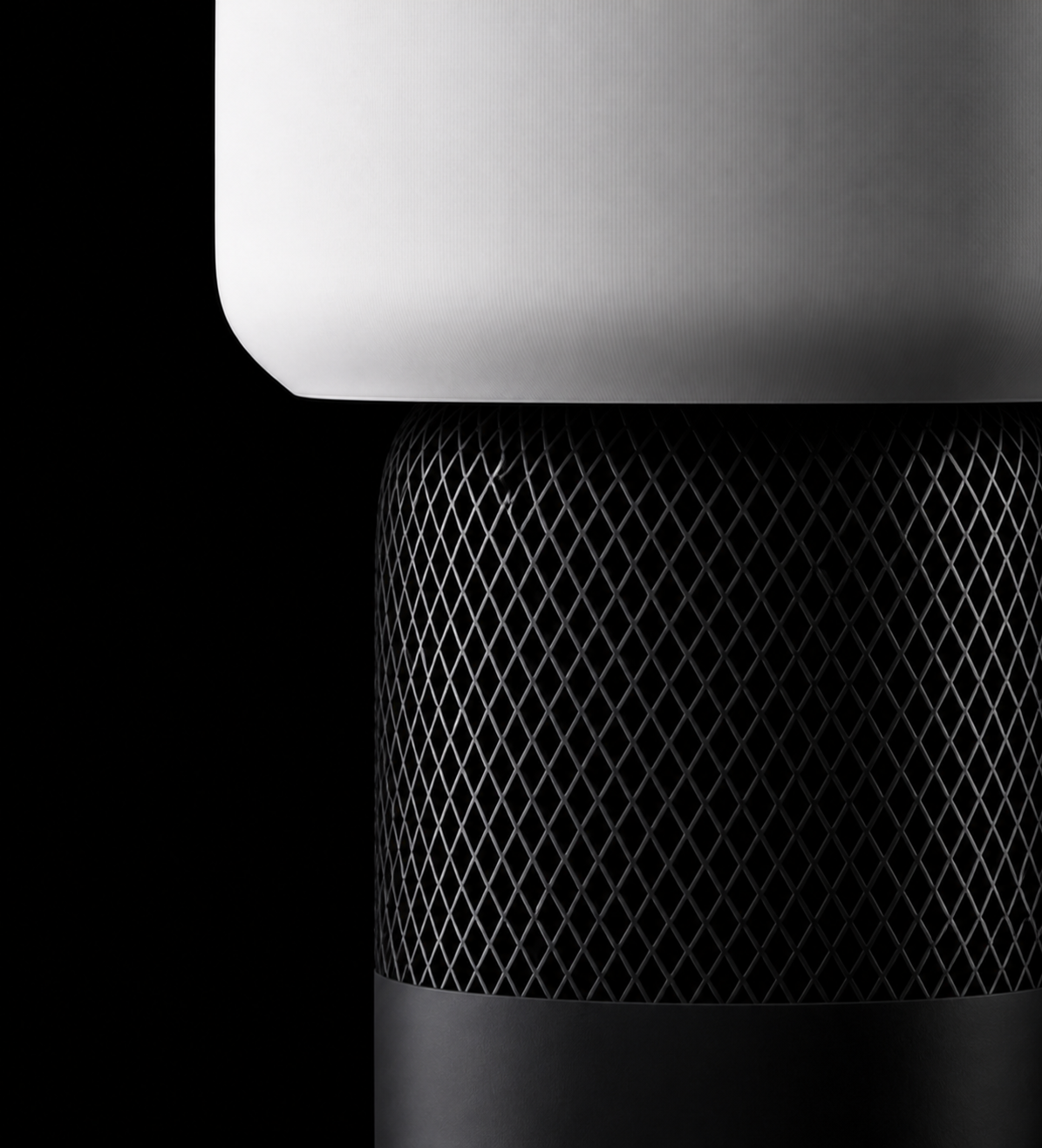 Close-up of the Lumo lamp featuring a softly illuminated white shade and textured black mesh base.
