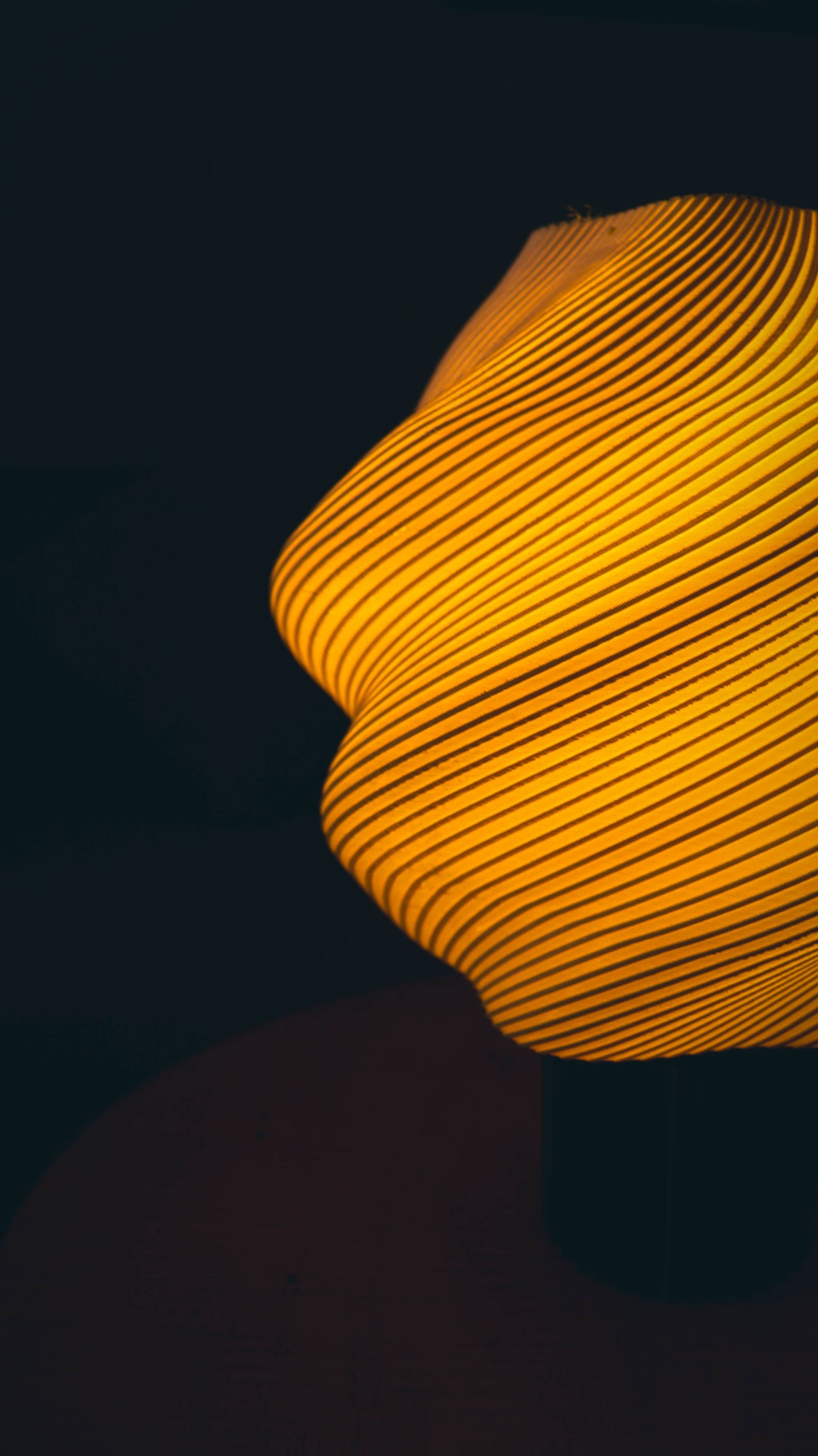 Close-up of a textured yellow lamp against a dark background