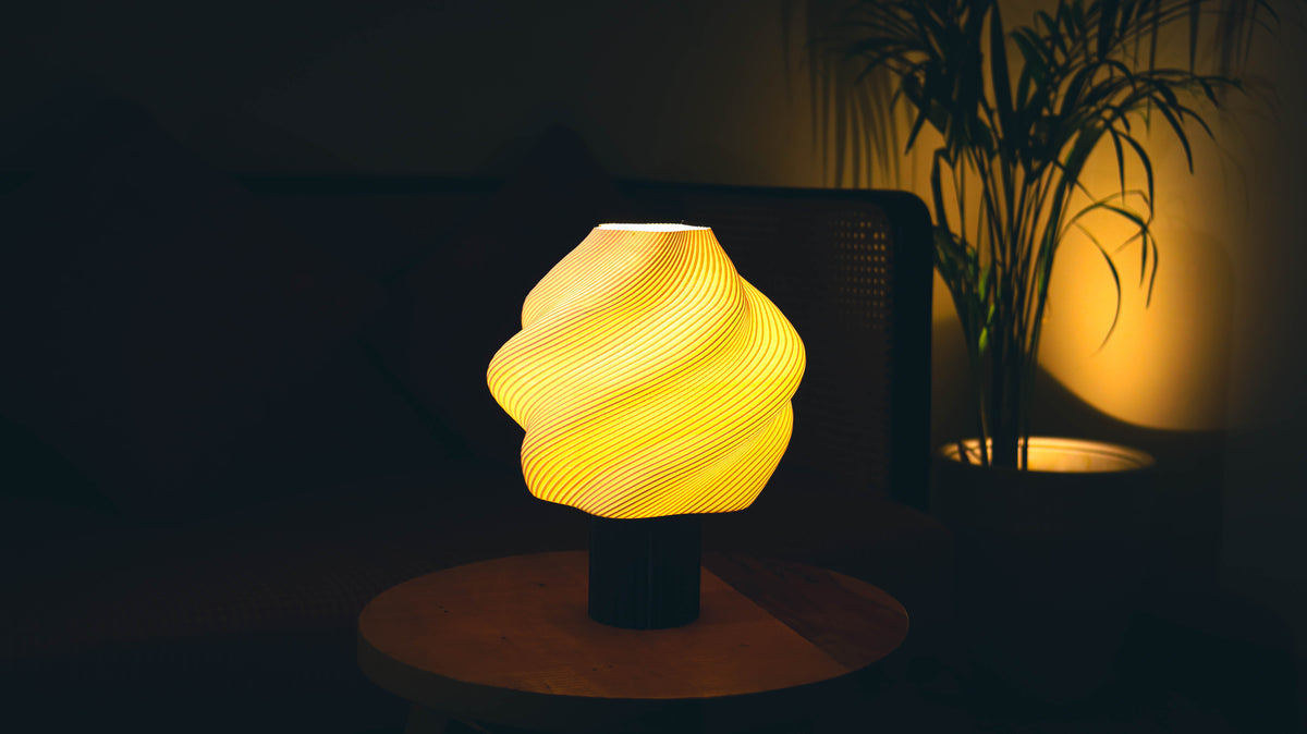 Soft serve table lamp illuminated at night, casting warm ambient light